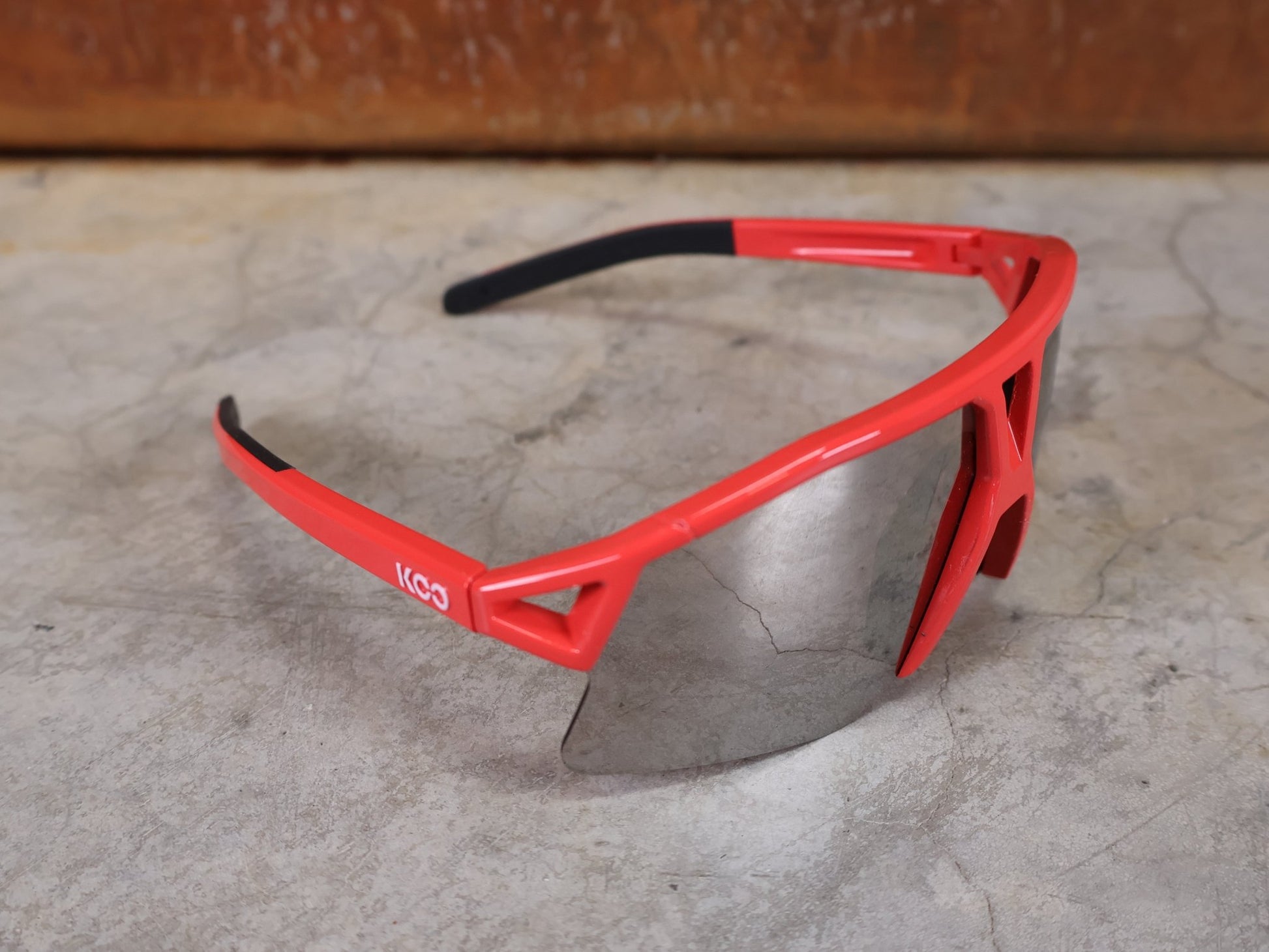 Brillen von Koo, KOO RED BULL - BORA HANSGROHE HYPE SONNENBRILLE / LEADER EDITION ROT vor USEDBIKES - OB.DE Hintergrund