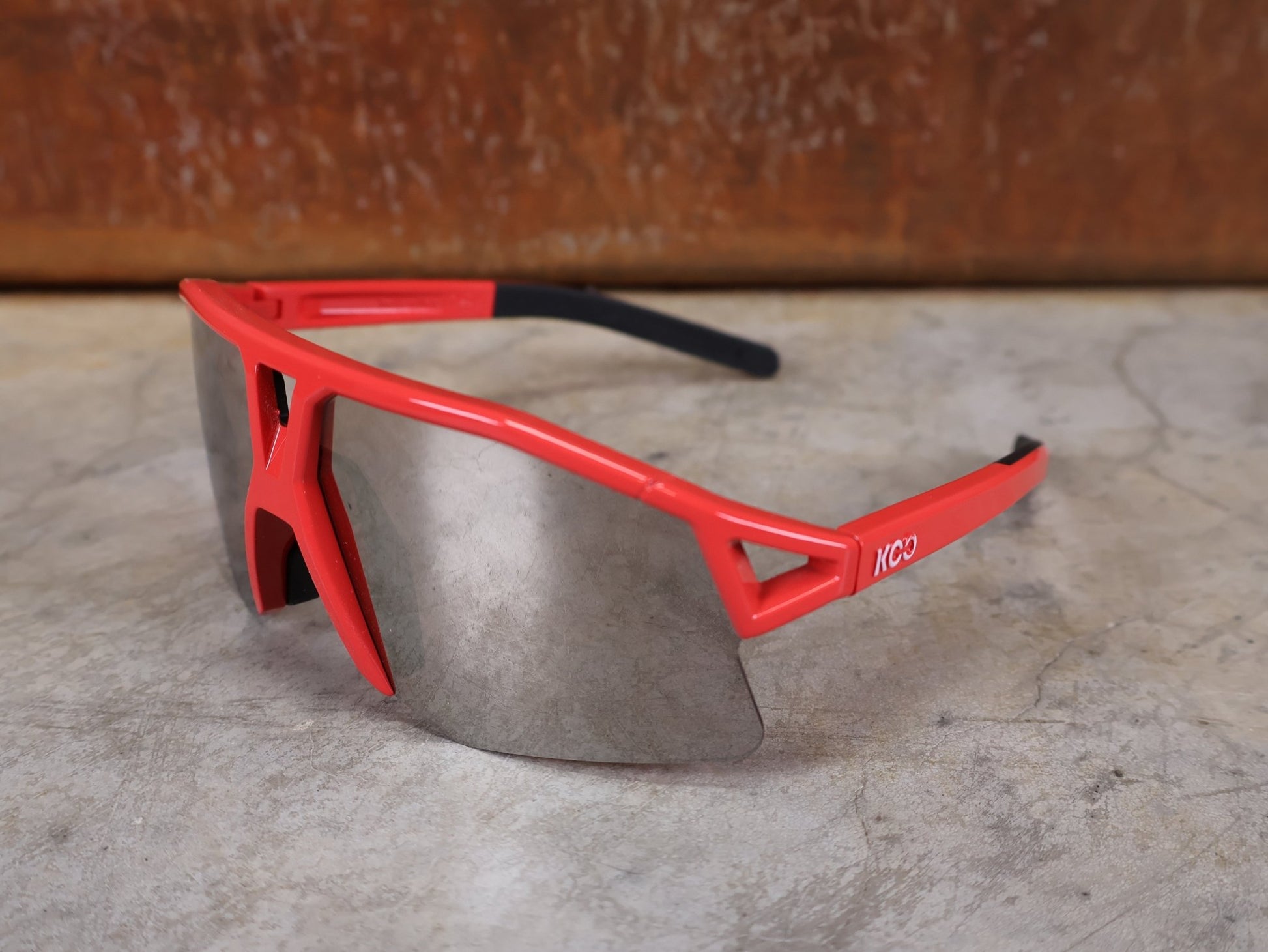 Brillen von Koo, KOO RED BULL - BORA HANSGROHE HYPE SONNENBRILLE / LEADER EDITION ROT vor USEDBIKES - OB.DE Hintergrund
