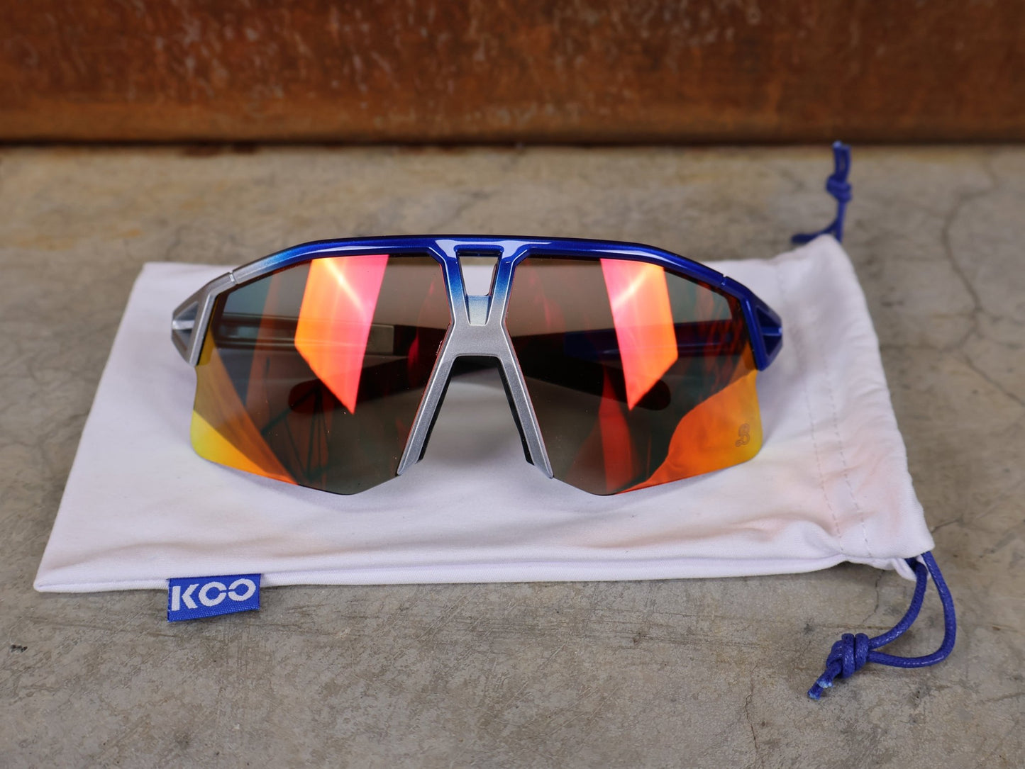 Brillen von Koo, KOO RED BULL - BORA HANSGROHE HYPE SONNENBRILLE / RED MIRROR vor USEDBIKES - OB.DE Hintergrund