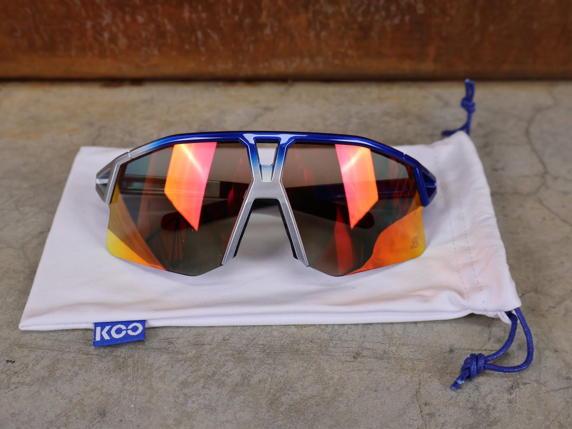 Brillen von Koo, KOO RED BULL - BORA HANSGROHE HYPE SONNENBRILLE / RED MIRROR vor USEDBIKES - OB.DE Hintergrund