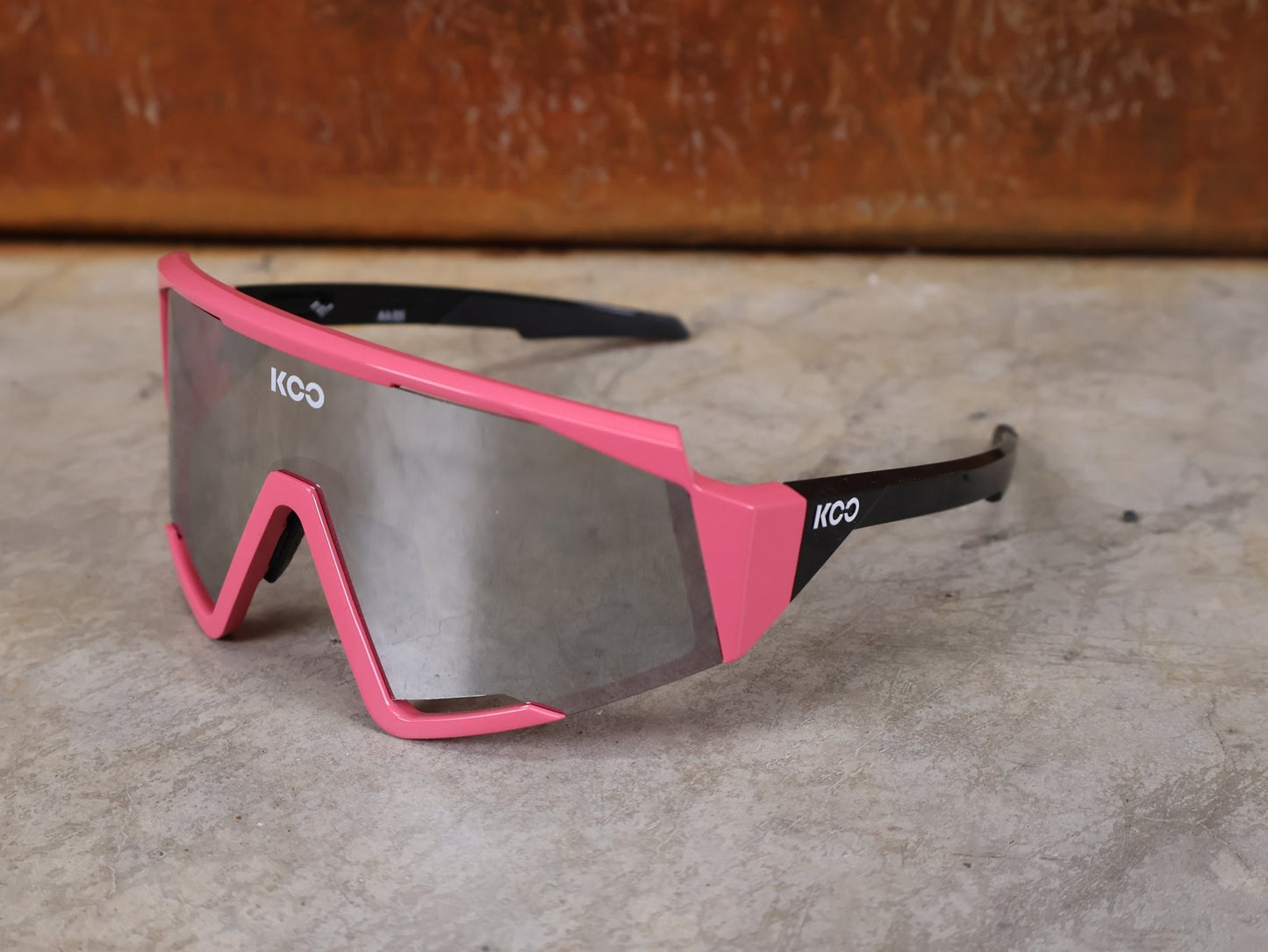 Brillen von Koo, KOO RED BULL - BORA HANSGROHE SPECTRO SONNENBRILLE / CHAMPION LEADER ROSA vor USEDBIKES - OB.DE Hintergrund