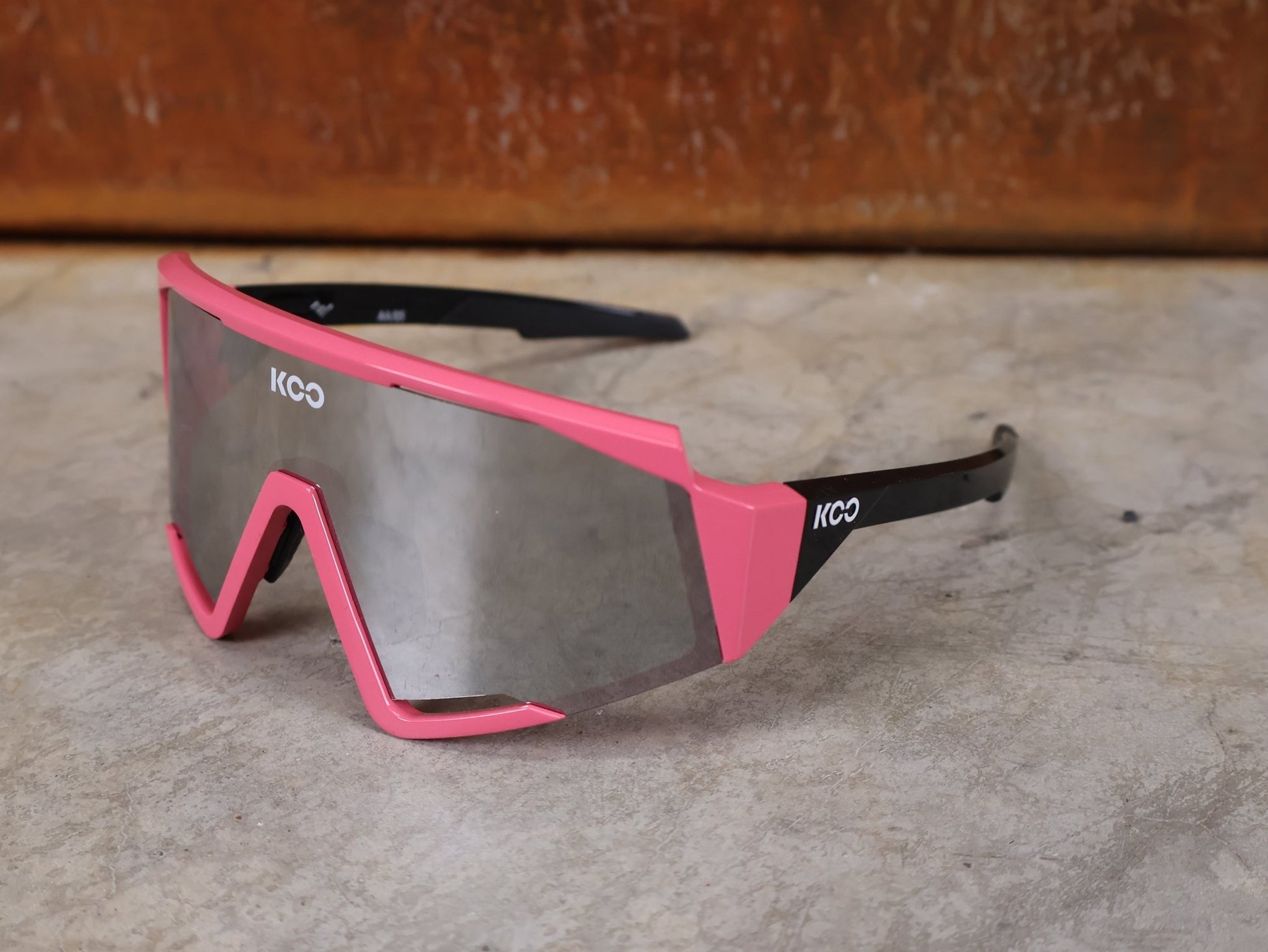 Brillen von Koo, KOO RED BULL - BORA HANSGROHE SPECTRO SONNENBRILLE / CHAMPION LEADER ROSA vor USEDBIKES - OB.DE Hintergrund