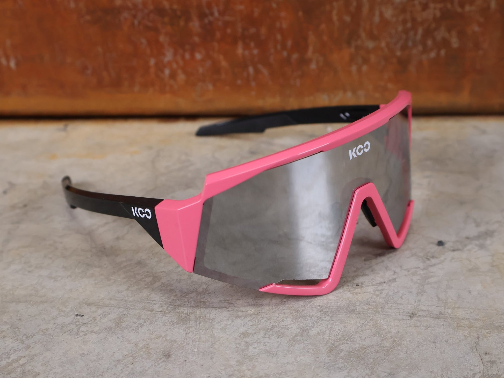 Brillen von Koo, KOO RED BULL - BORA HANSGROHE SPECTRO SONNENBRILLE / CHAMPION LEADER ROSA vor USEDBIKES - OB.DE Hintergrund