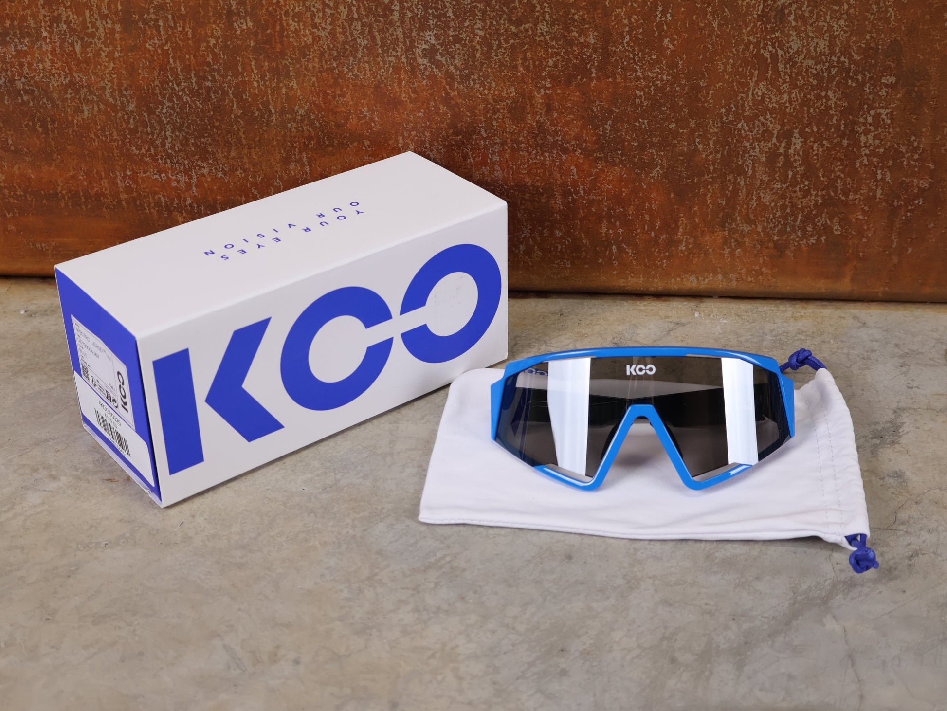 Brillen von Koo, KOO RED BULL - BORA HANSGROHE SPECTRO SONNENBRILLE / LEADER EDITION BLAU vor USEDBIKES - OB.DE Hintergrund