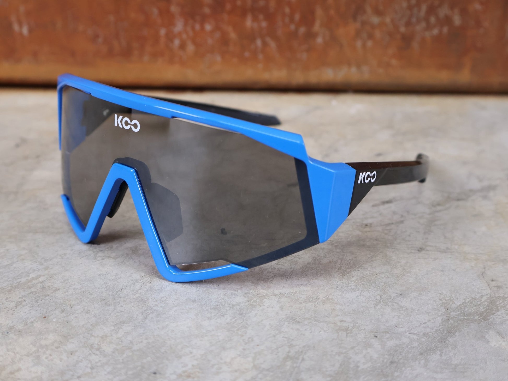 Brillen von Koo, KOO RED BULL - BORA HANSGROHE SPECTRO SONNENBRILLE / LEADER EDITION BLAU vor USEDBIKES - OB.DE Hintergrund