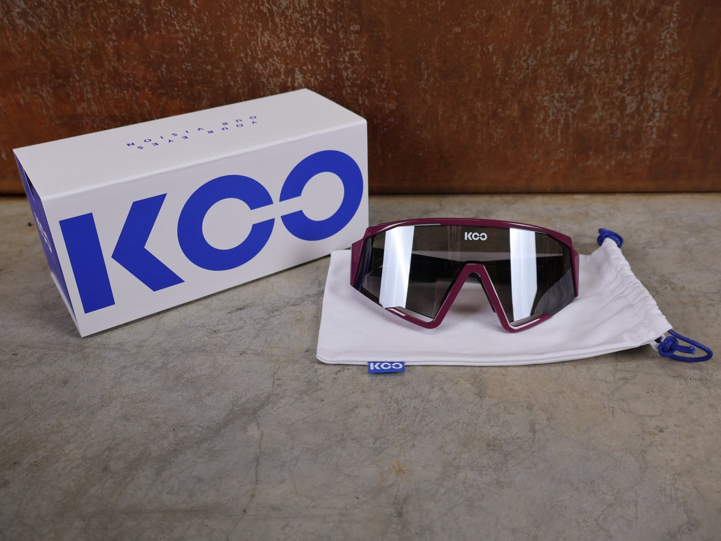 Brillen von Koo, KOO RED BULL - BORA HANSGROHE SPECTRO SONNENBRILLE / LEADER EDITION MAGLIA CICLAMINO vor USEDBIKES - OB.DE Hintergrund