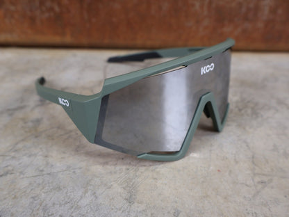 Brillen von Koo, KOO RED BULL - BORA HANSGROHE SPECTRO SONNENBRILLE / OLIVE GRÜN MATT vor USEDBIKES - OB.DE Hintergrund