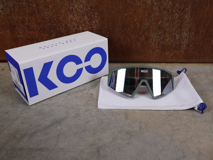 Brillen von Koo, KOO RED BULL - BORA HANSGROHE SPECTRO SONNENBRILLE / OLIVE GRÜN MATT vor USEDBIKES - OB.DE Hintergrund