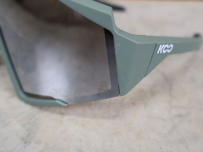 Brillen von Koo, KOO RED BULL - BORA HANSGROHE SPECTRO SONNENBRILLE / OLIVE GRÜN MATT vor USEDBIKES - OB.DE Hintergrund