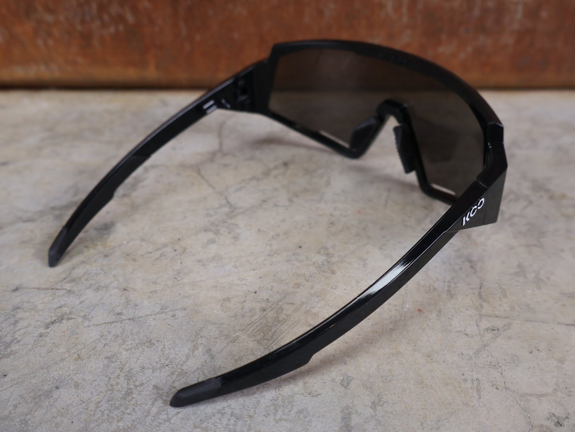 Brillen von Koo, KOO RED BULL - BORA HANSGROHE SPECTRO SONNENBRILLE / SCHWARZ GLANZ vor USEDBIKES - OB.DE Hintergrund