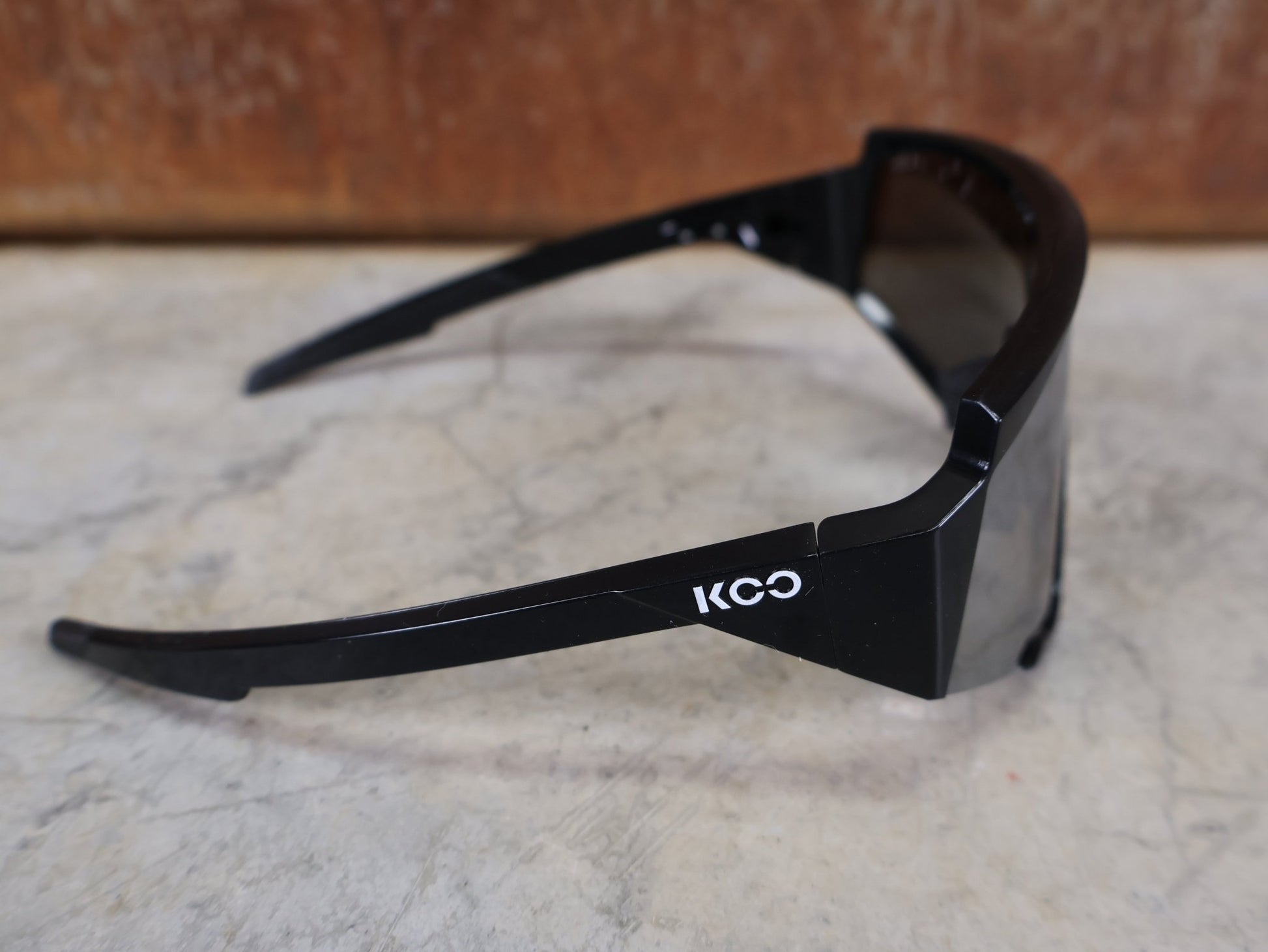 Brillen von Koo, KOO RED BULL - BORA HANSGROHE SPECTRO SONNENBRILLE / SCHWARZ GLANZ vor USEDBIKES - OB.DE Hintergrund