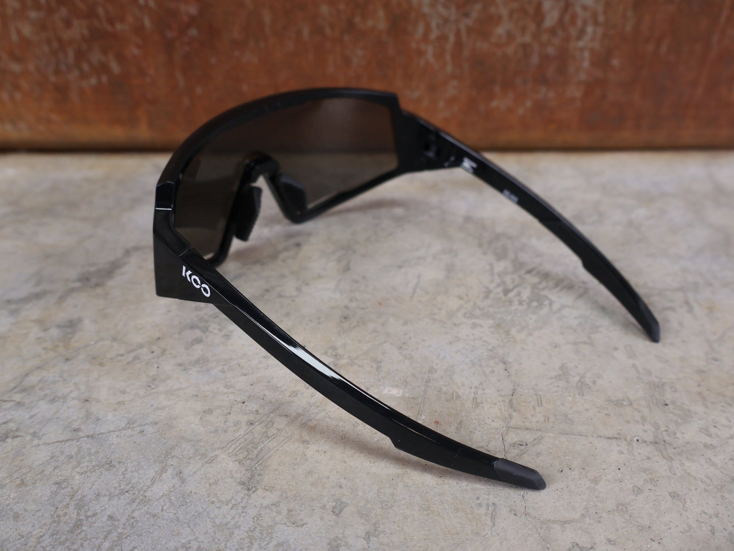 Brillen von Koo, KOO RED BULL - BORA HANSGROHE SPECTRO SONNENBRILLE / SCHWARZ GLANZ vor USEDBIKES - OB.DE Hintergrund