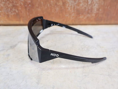 Brillen von Koo, KOO RED BULL - BORA HANSGROHE SPECTRO SONNENBRILLE / SCHWARZ GLANZ vor USEDBIKES - OB.DE Hintergrund