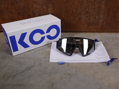 Brillen von Koo, KOO RED BULL - BORA HANSGROHE SPECTRO SONNENBRILLE / SCHWARZ MATT vor USEDBIKES - OB.DE Hintergrund