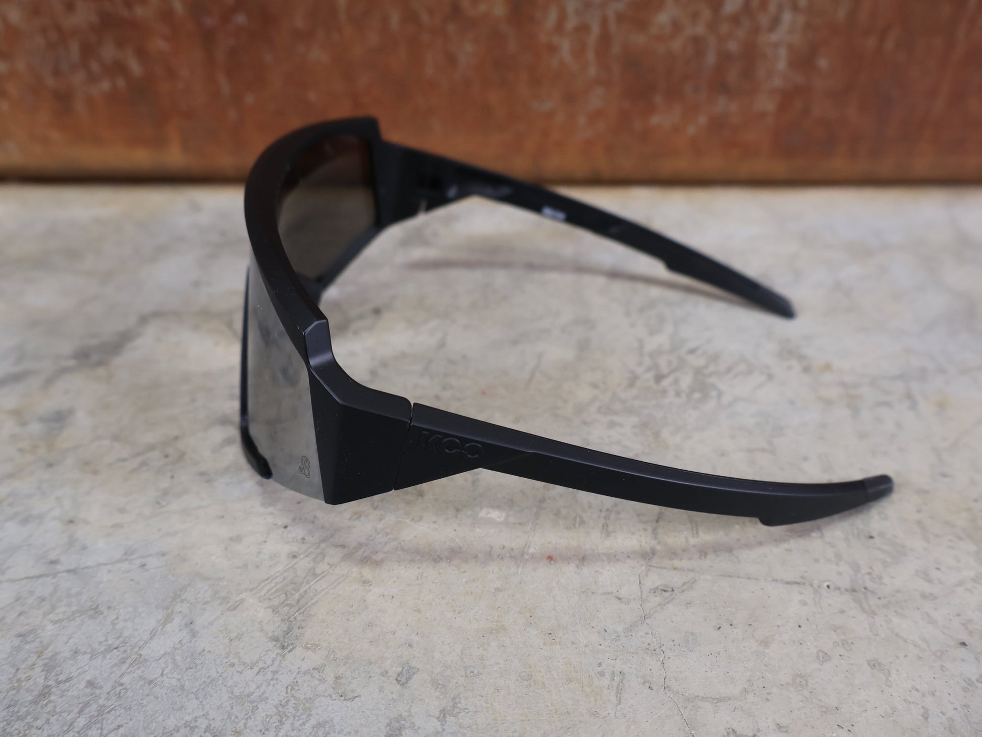 Brillen von Koo, KOO RED BULL - BORA HANSGROHE SPECTRO SONNENBRILLE / SCHWARZ MATT vor USEDBIKES - OB.DE Hintergrund