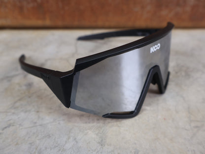 Brillen von Koo, KOO RED BULL - BORA HANSGROHE SPECTRO SONNENBRILLE / SCHWARZ MATT vor USEDBIKES - OB.DE Hintergrund
