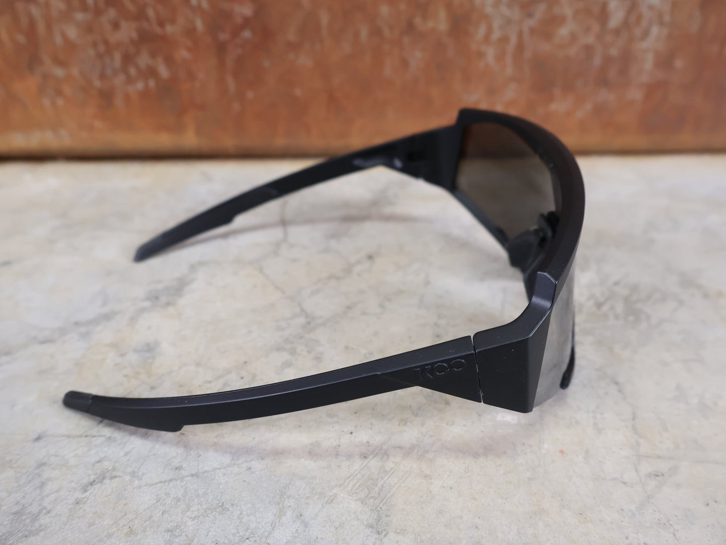 Brillen von Koo, KOO RED BULL - BORA HANSGROHE SPECTRO SONNENBRILLE / SCHWARZ MATT vor USEDBIKES - OB.DE Hintergrund