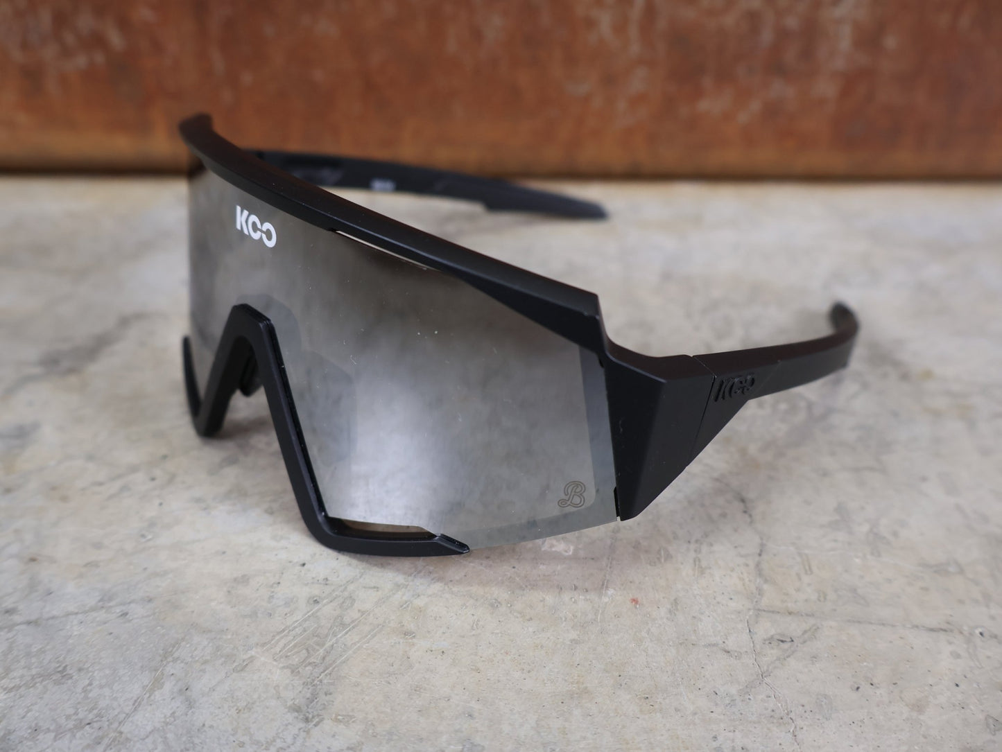 Brillen von Koo, KOO RED BULL - BORA HANSGROHE SPECTRO SONNENBRILLE / SCHWARZ MATT vor USEDBIKES - OB.DE Hintergrund