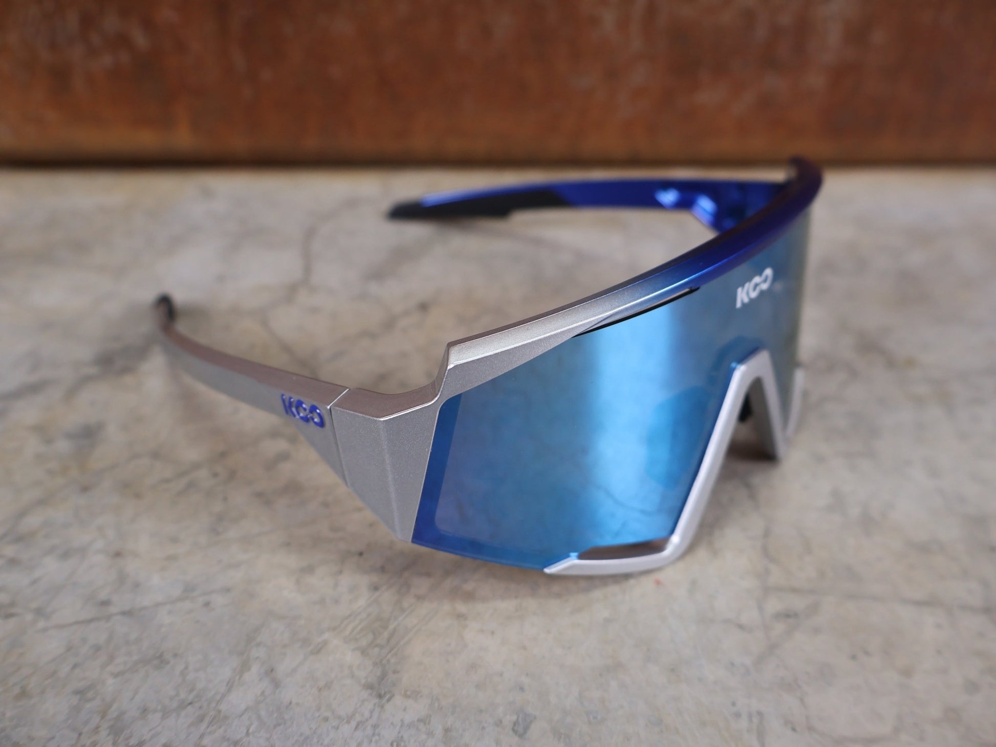 Brillen von Koo, KOO RED BULL - BORA HANSGROHE SPECTRO SONNENBRILLE / TURQUOISE MIRROR vor USEDBIKES - OB.DE Hintergrund