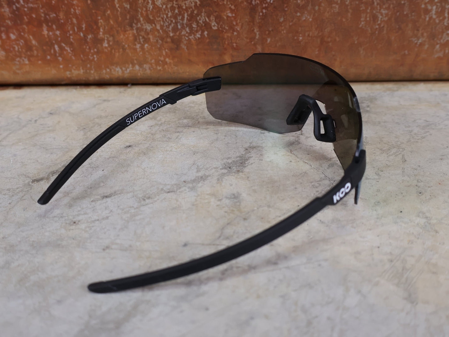Brillen von Koo, KOO SUPERNOVA SONNENBRILLE / BLACK MATT GREEN MIRROR vor USEDBIKES - OB.DE Hintergrund