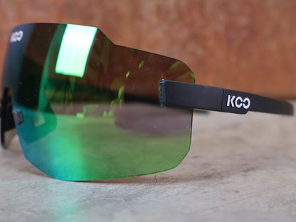Brillen von Koo, KOO SUPERNOVA SONNENBRILLE / BLACK MATT GREEN MIRROR vor USEDBIKES - OB.DE Hintergrund