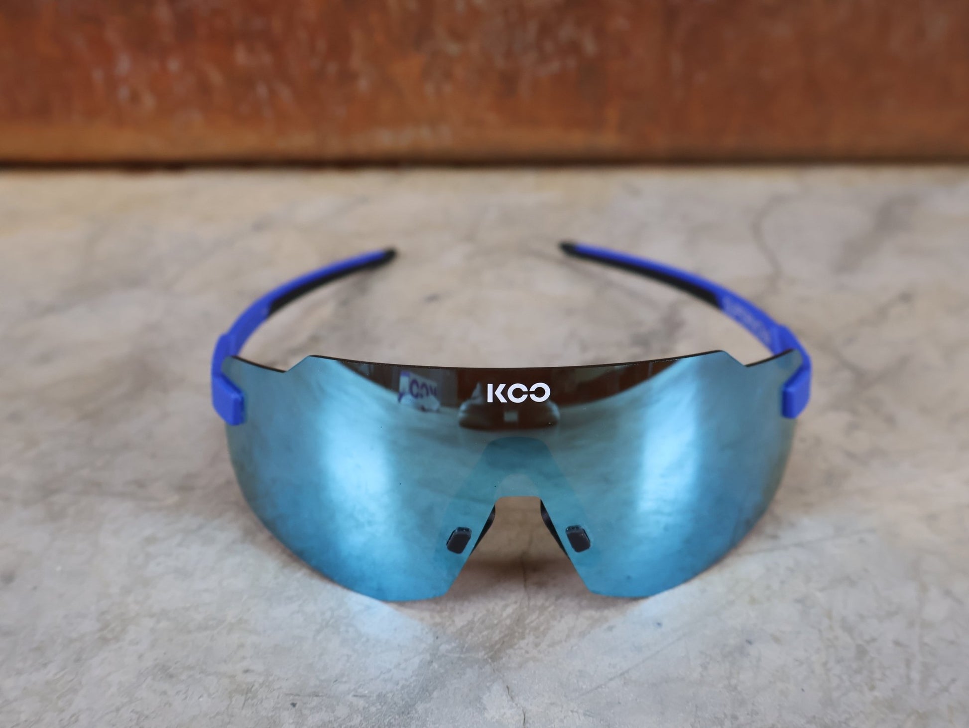 Brillen von Koo, KOO SUPERNOVA SONNENBRILLE / BLUE MATT TURQUOISE MIRROR vor USEDBIKES - OB.DE Hintergrund