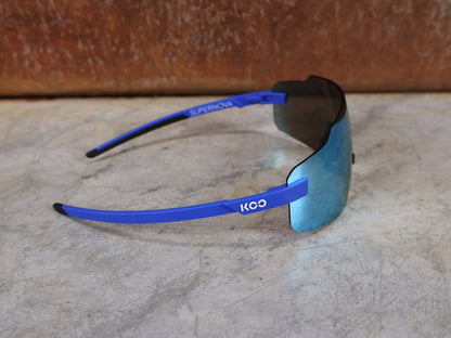Brillen von Koo, KOO SUPERNOVA SONNENBRILLE / BLUE MATT TURQUOISE MIRROR vor USEDBIKES - OB.DE Hintergrund