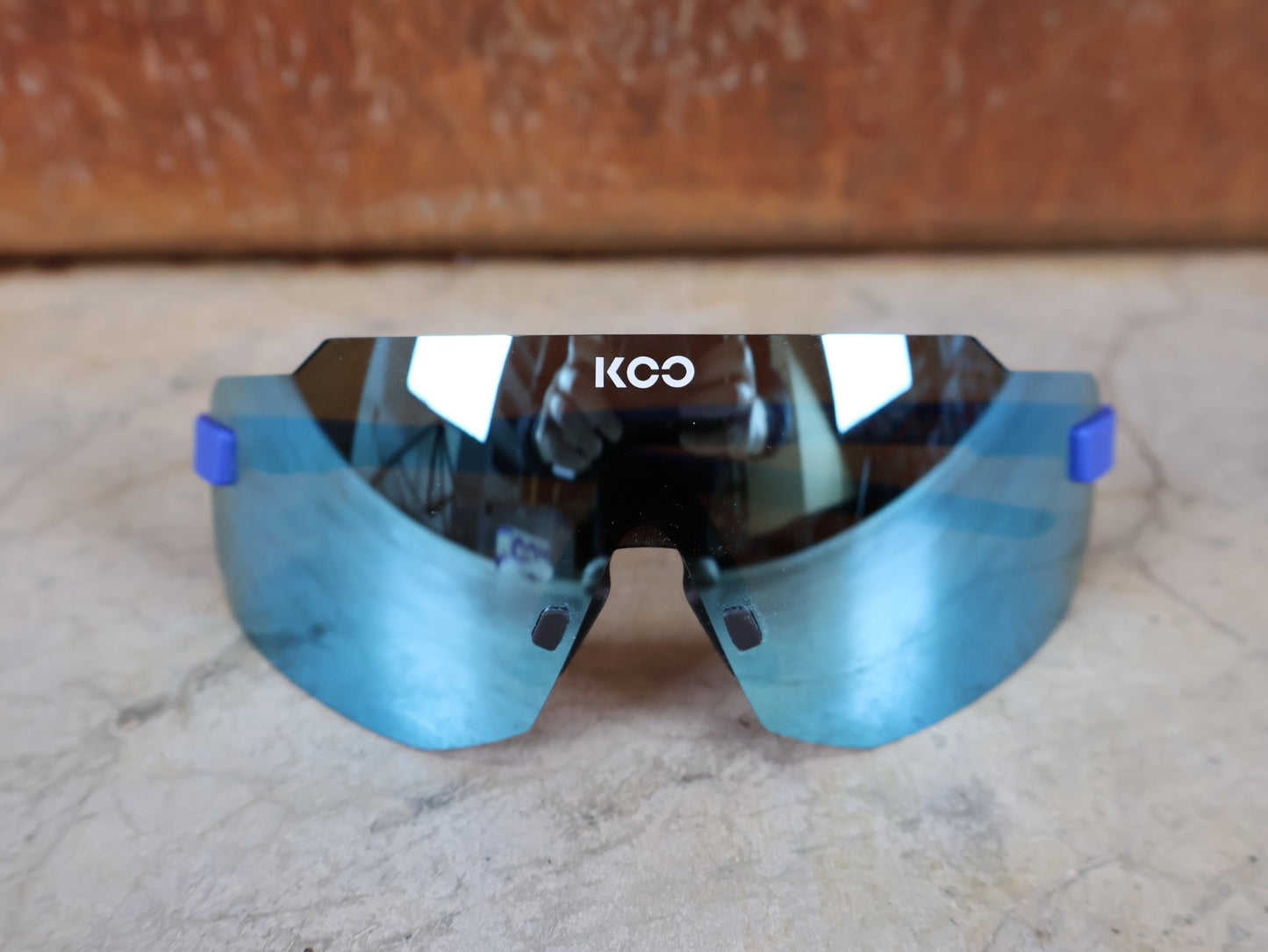 Brillen von Koo, KOO SUPERNOVA SONNENBRILLE / BLUE MATT TURQUOISE MIRROR vor USEDBIKES - OB.DE Hintergrund