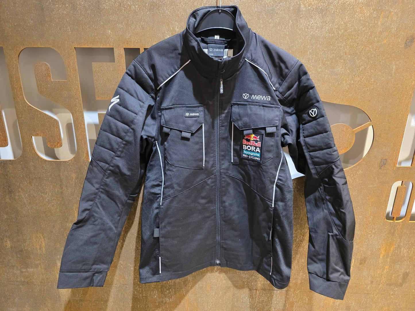 Freizeitbekleidung - BOH von Mewa, MEWA RED BULL - BORA HANSGROHE PEAK ARBEITSJACKE STAFF / HERREN in variant_title vor USEDBIKES - OB.DE Hintergrund