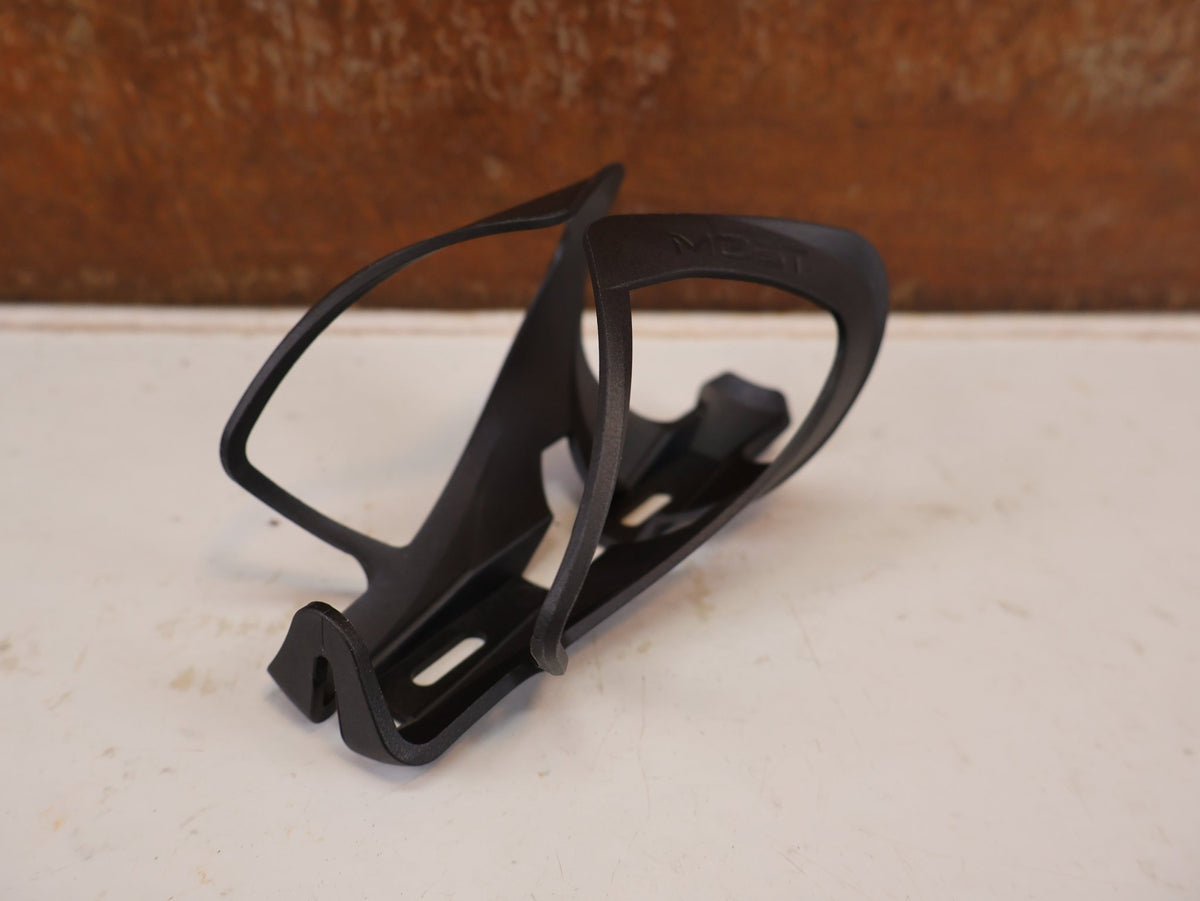 Trinkflaschen und Halter von Most, MOST TRAP PACF FLASCHENHALTER CARBON SCHWARZ 31G vor USEDBIKES-OB.DE Hintergrund