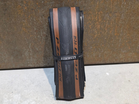 Reifen von Pirelli, PIRELLI P ZERO RACE TLR RENNRADREIFEN / BRAUN / 700 X 28MM vor USEDBIKES - OB.DE Hintergrund