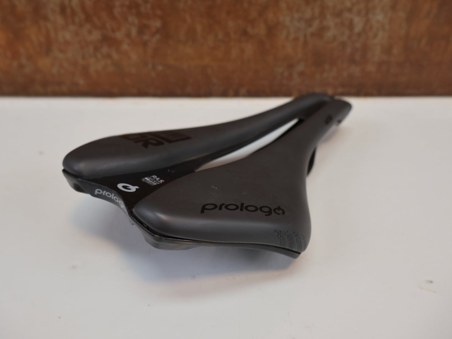 Sattel von Prologo, PROLOGO DIMENSION NDR T4.0 SATTEL / 245X143 MM / UNISEX / SCHWARZ / 253G vor USEDBIKES - OB.DE Hintergrund