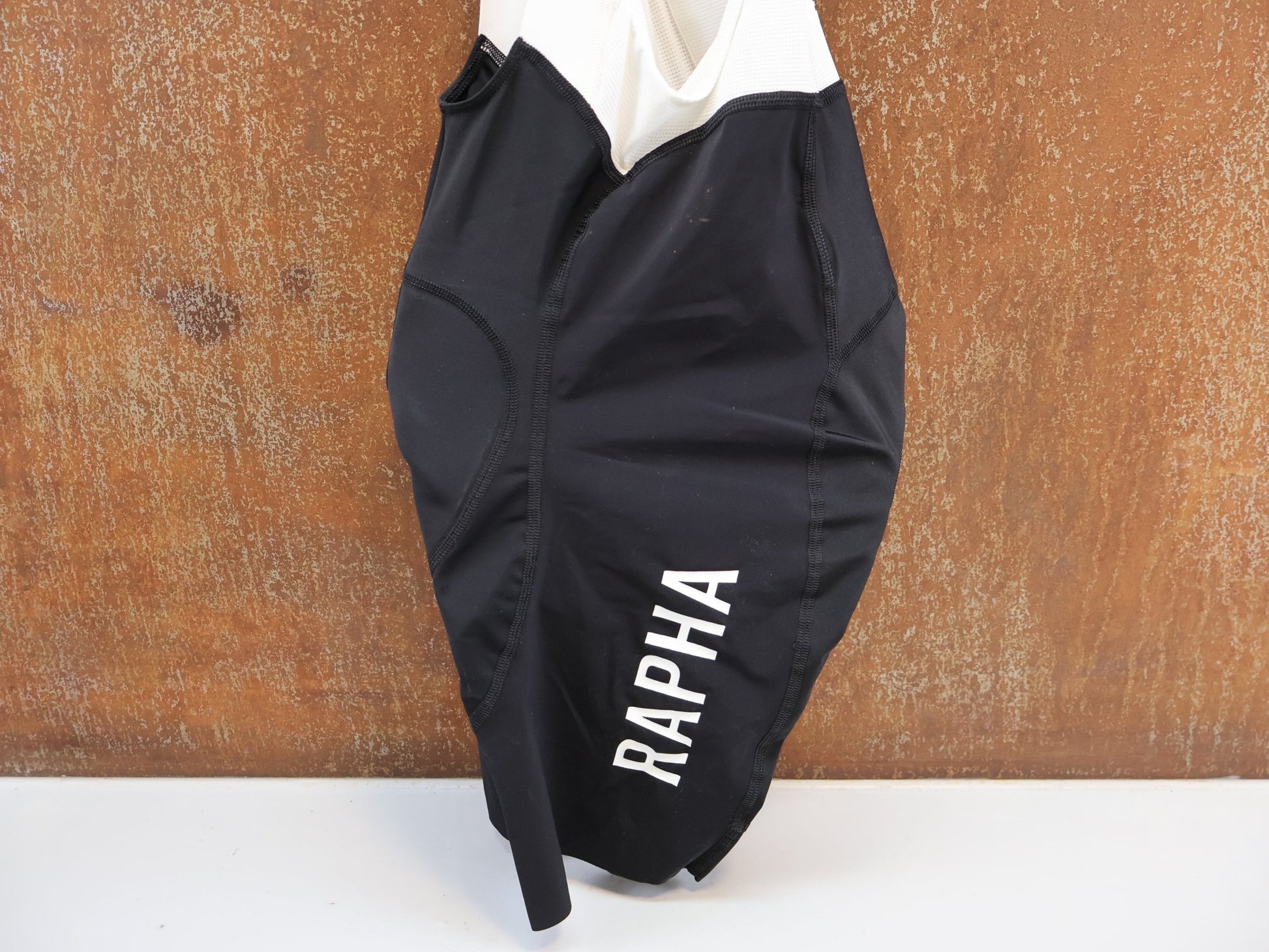 Hosen Herren von Rapha, RAPHA PRO TEAM CYCLING BIB SHORT / GRÖSSE S / BLACK - WHITE / PERFORMANCE vor USEDBIKES - OB.DE Hintergrund