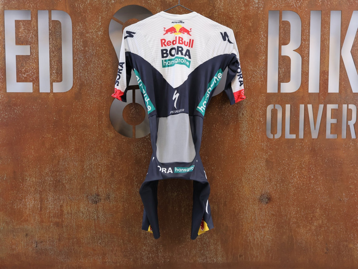 Anzug - BOH von Specialized, Red Bull BORA hansgrohe Aero Skinsuit Kurzarm Specialized vor USEDBIKES-OB.DE Hintergrund