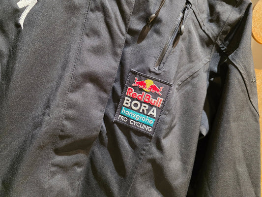 Freizeitbekleidung - BOH von Schöffel, RED BULL - BORA HANSGROHE SCHÖFFEL PRO HIGH - END WETTERSCHUTZJACKE ZIPIN JACKE / DAMEN in variant_title vor USEDBIKES - OB.DE Hintergrund