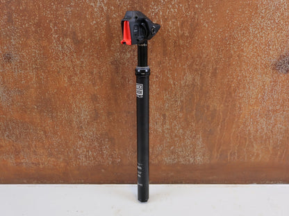 Sattelstütze von Rock Shox, ROCK SHOX REVERB AXS XPLR VARIO SATTELSTÜTZE 27.2X400 50MM vor USEDBIKES-OB.DE Hintergrund