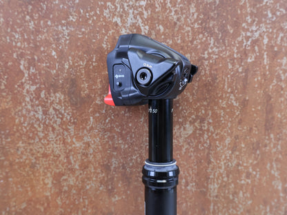 Sattelstütze von Rock Shox, ROCK SHOX REVERB AXS XPLR VARIO SATTELSTÜTZE 27.2X400 50MM vor USEDBIKES-OB.DE Hintergrund