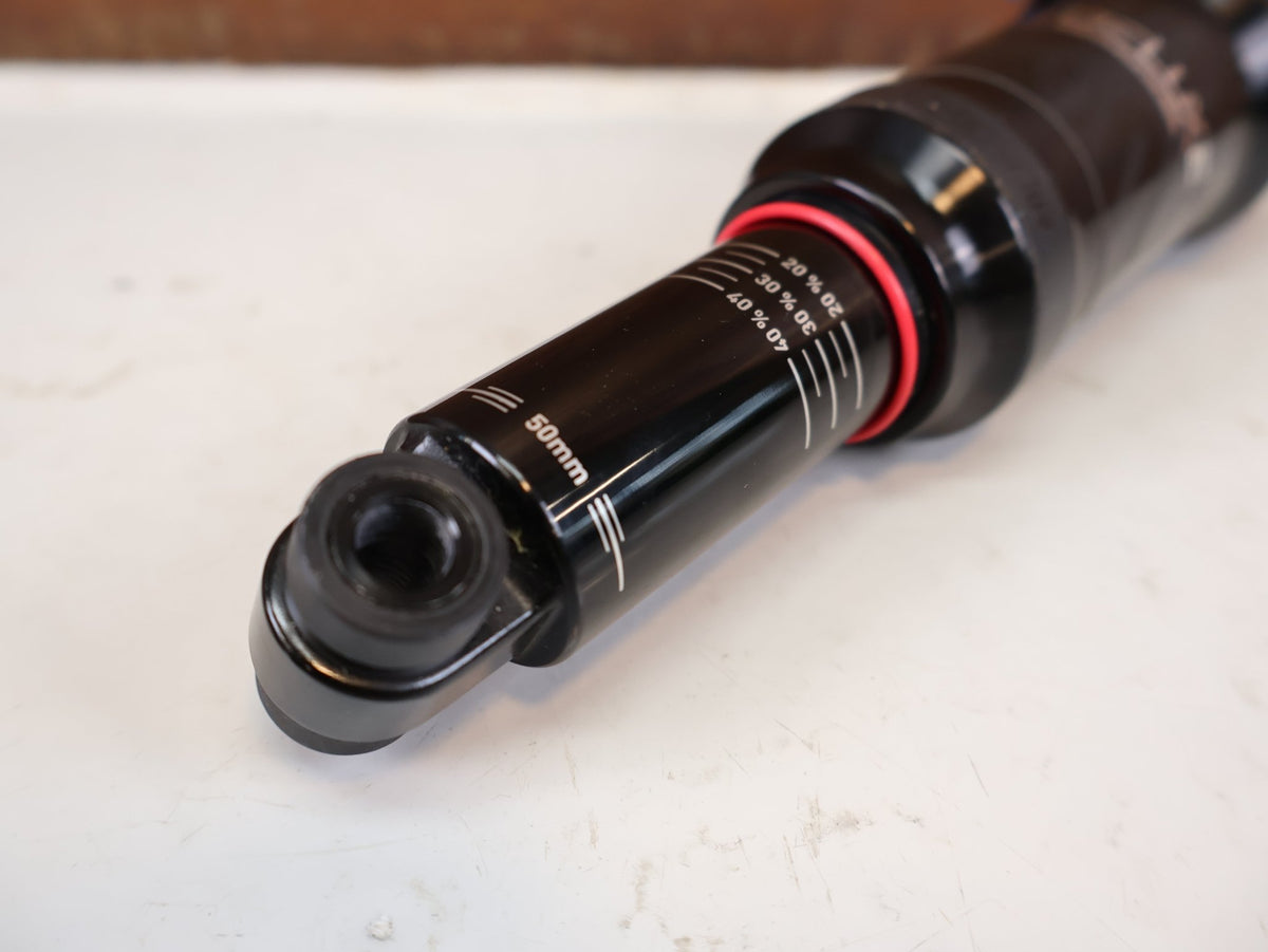 Federgabel & Dämpfer von Rock Shox, RockShox Deluxe Ultimate RCT DebonAir Trunnion 185x50 Dämpfer vor USEDBIKES-OB.DE Hintergrund