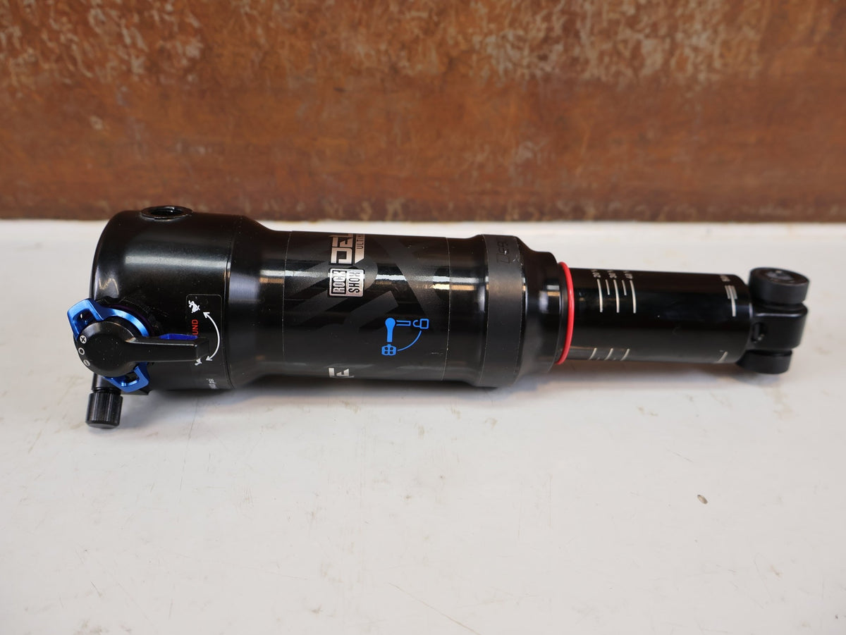 Federgabel & Dämpfer von Rock Shox, RockShox Deluxe Ultimate RCT DebonAir Trunnion 185x50 Dämpfer vor USEDBIKES-OB.DE Hintergrund