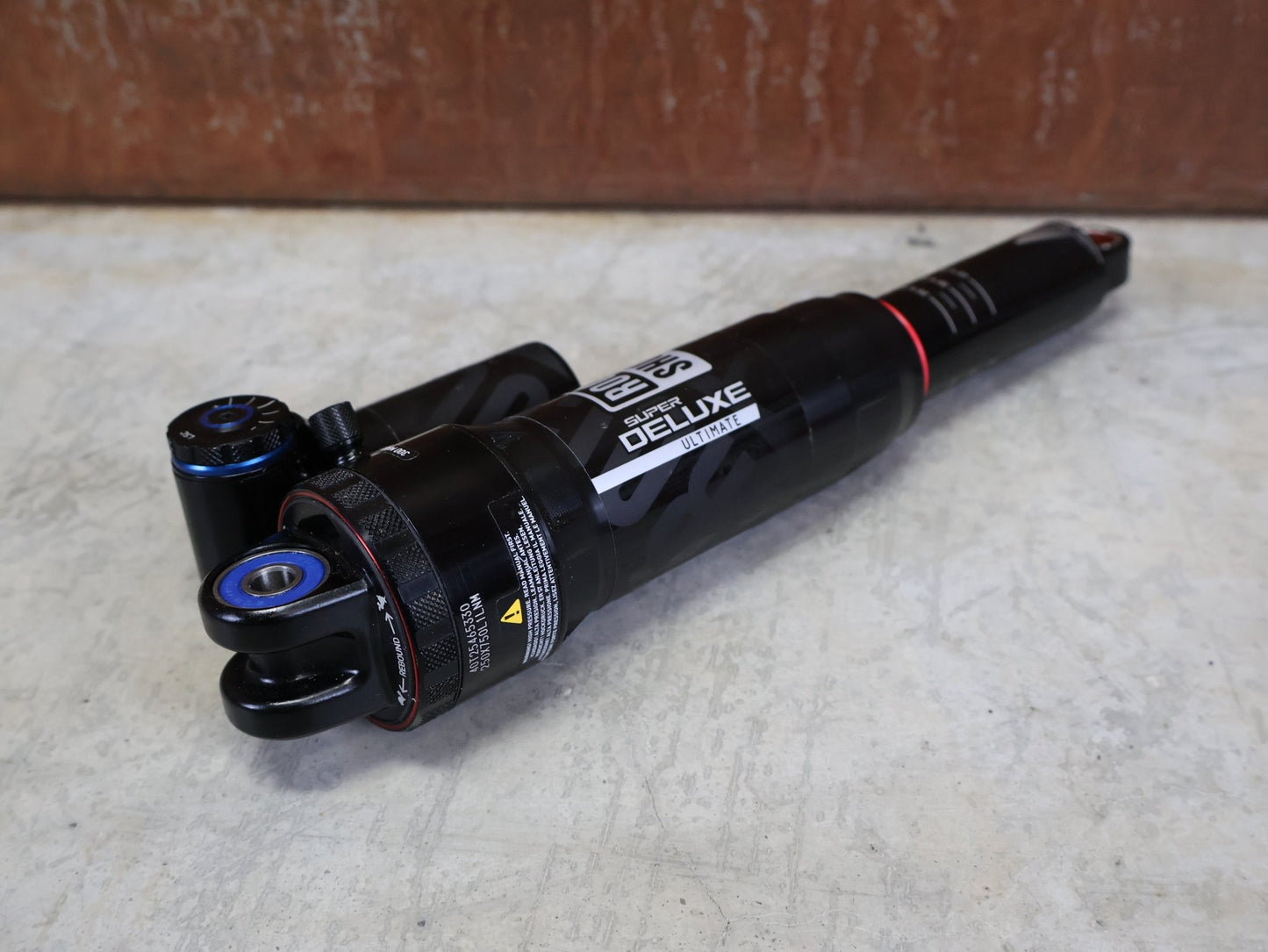 Federgabel & Dämpfer von Rock Shox, ROCKSHOX SUPER DELUXE ULTIMATE DH DÄMPFER 250X75 MM – DEBONAIR vor USEDBIKES - OB.DE Hintergrund