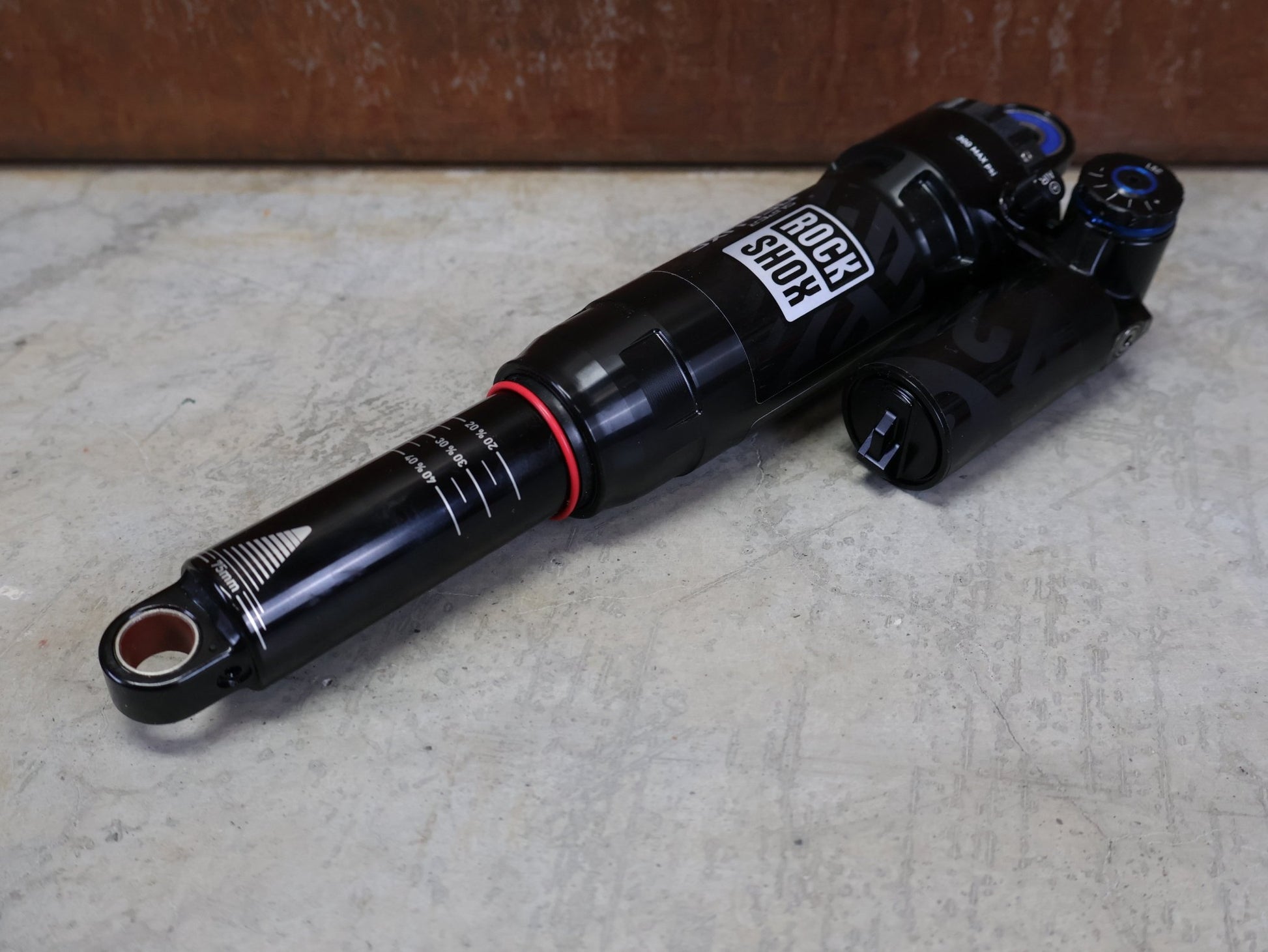 Federgabel & Dämpfer von Rock Shox, ROCKSHOX SUPER DELUXE ULTIMATE DH DÄMPFER 250X75 MM – DEBONAIR vor USEDBIKES - OB.DE Hintergrund