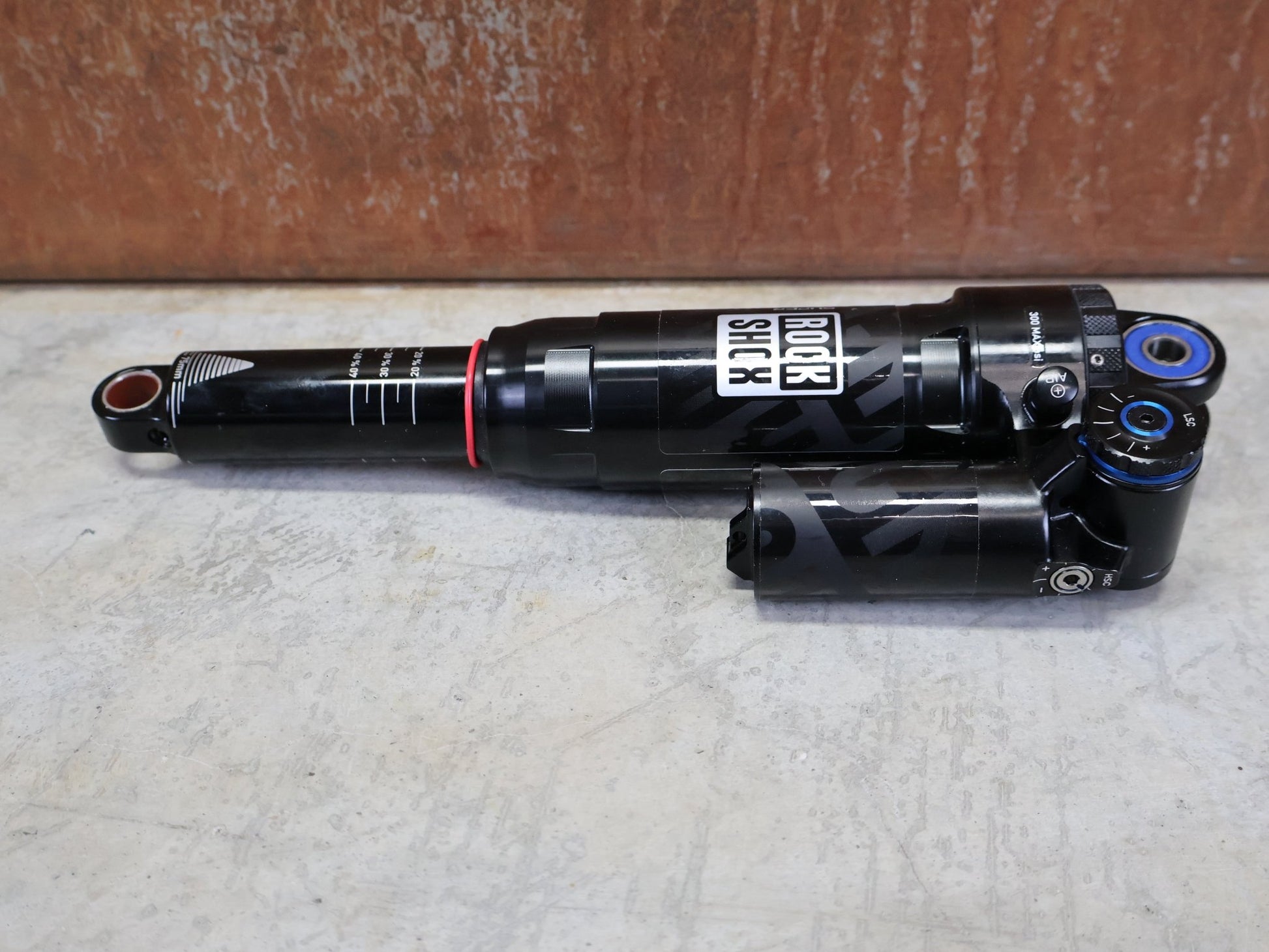 Federgabel & Dämpfer von Rock Shox, ROCKSHOX SUPER DELUXE ULTIMATE DH DÄMPFER 250X75 MM – DEBONAIR vor USEDBIKES - OB.DE Hintergrund