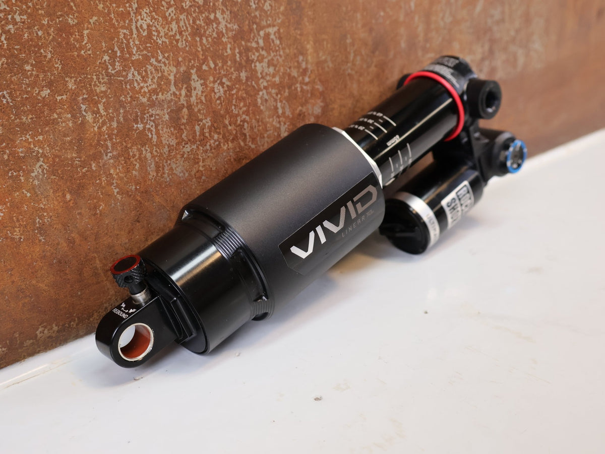 Federgabel & Dämpfer von Rock Shox, RockShox Vivid Ultimate Air Dämpfer 205x65mm Trunnion RC2T vor USEDBIKES-OB.DE Hintergrund