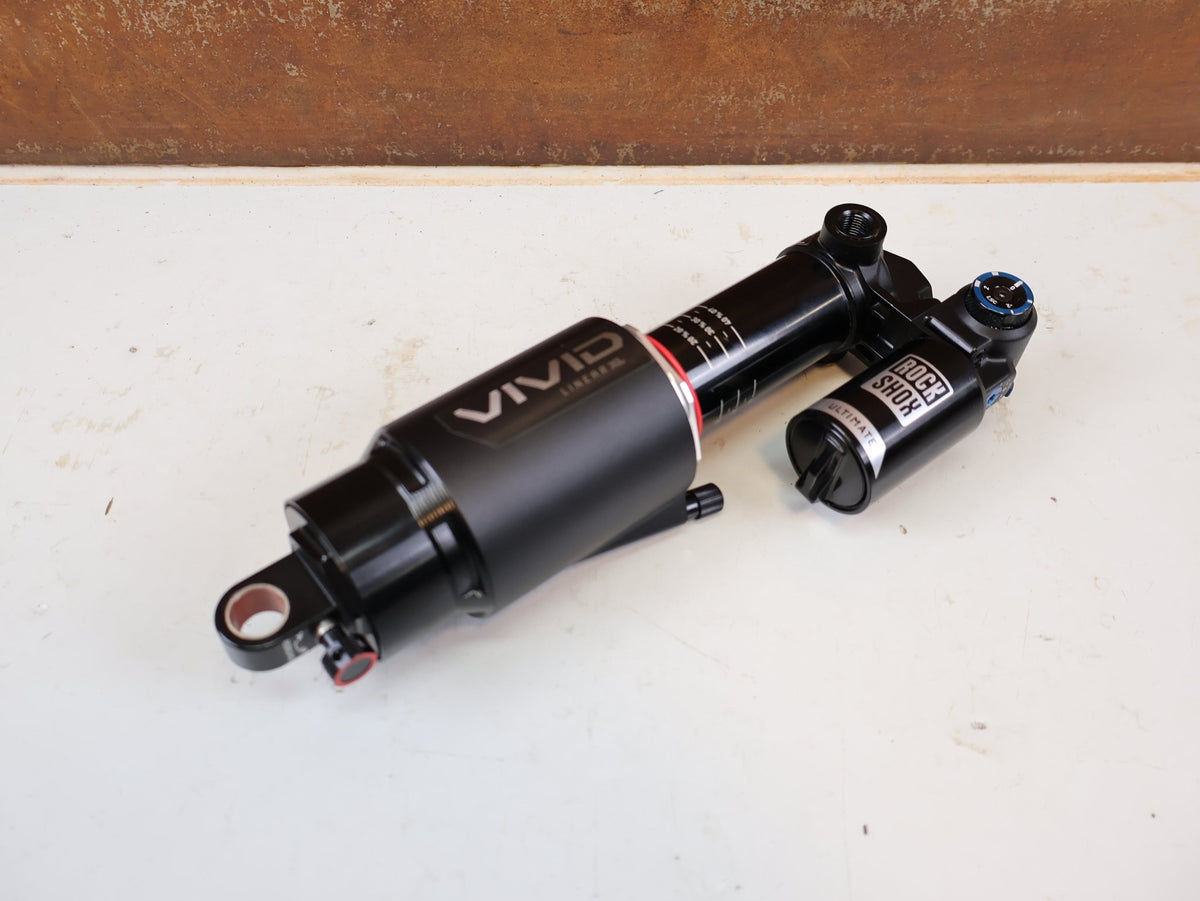 Federgabel & Dämpfer von Rock Shox, RockShox Vivid Ultimate Air Dämpfer 205x65mm Trunnion RC2T vor USEDBIKES-OB.DE Hintergrund
