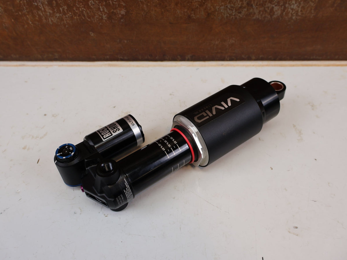 Federgabel & Dämpfer von Rock Shox, RockShox Vivid Ultimate Air Dämpfer 205x65mm Trunnion RC2T vor USEDBIKES-OB.DE Hintergrund