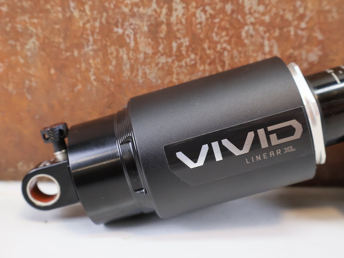 Federgabel & Dämpfer von Rock Shox, RockShox Vivid Ultimate Air Dämpfer 205x65mm Trunnion RC2T vor USEDBIKES-OB.DE Hintergrund
