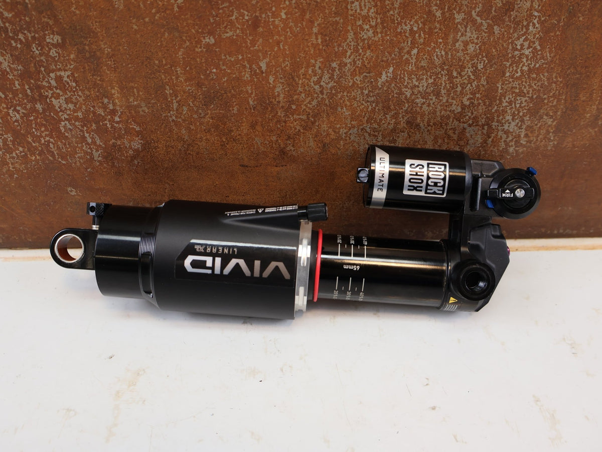 Federgabel & Dämpfer von Rock Shox, RockShox Vivid Ultimate Air Dämpfer 205x65mm Trunnion RC2T vor USEDBIKES-OB.DE Hintergrund