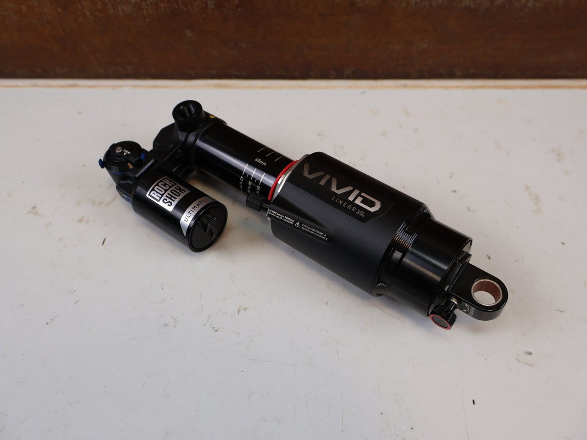 Federgabel & Dämpfer von Rock Shox, RockShox Vivid Ultimate Air Dämpfer 205x65mm Trunnion RC2T vor USEDBIKES-OB.DE Hintergrund