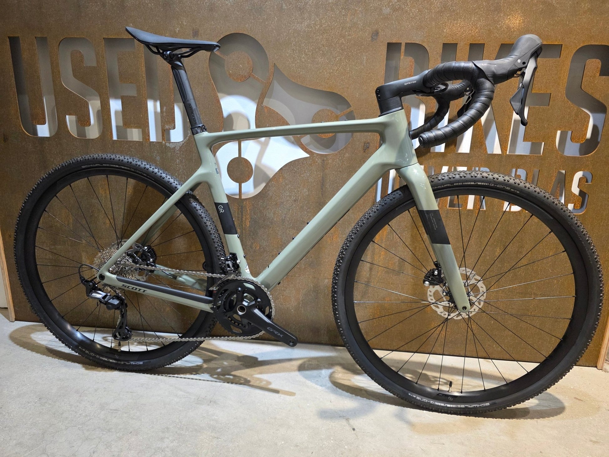 Gravel/Cyclocross von Scott, SCOTT ADDICT GRAVEL 50 / UNDERGROWT GREEN / M vor USEDBIKES - OB.DE Hintergrund