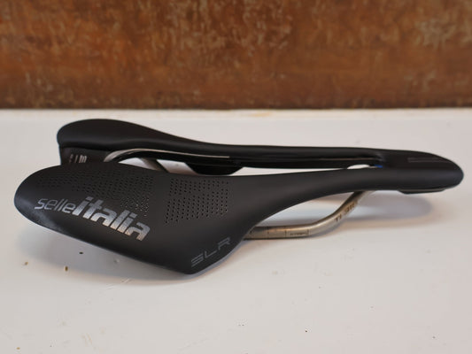 Sattel von Prologo, SELLE ITALIA SLR BOOST TI SUPERFLOW / RENNRAD SATTEL / S3 130 MM / TITAN vor USEDBIKES-OB.DE Hintergrund